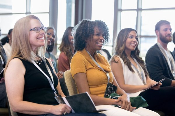 People smiling at a conference.