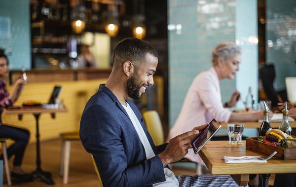 A person using a tablet in a cafe.