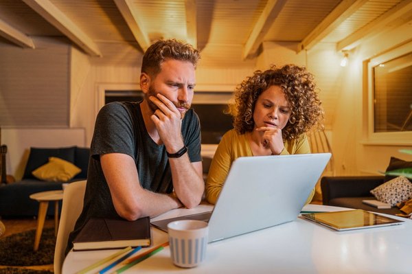 Couple looking concerned at computer screen