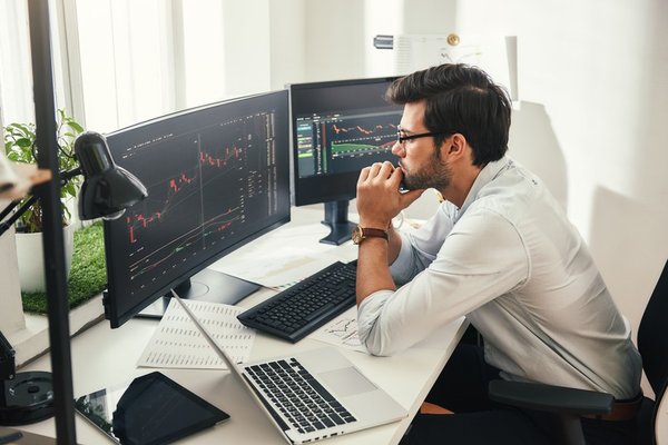 A person looking at a stock chart on a computer screen.