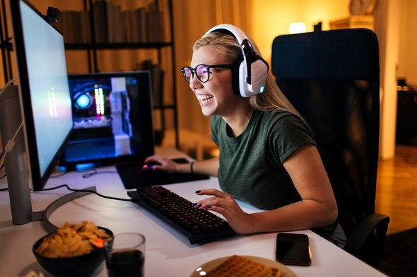 A young woman smiling while she uses her computer.