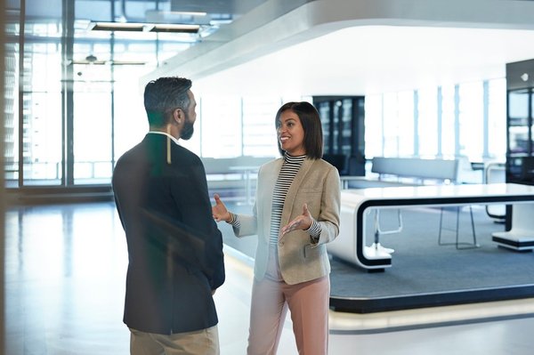 Woman speaking with man in office.