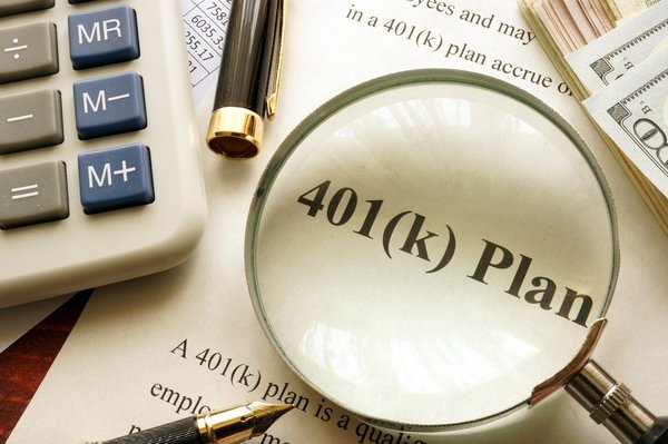 401K plan document is inspected with a magnifying glass.