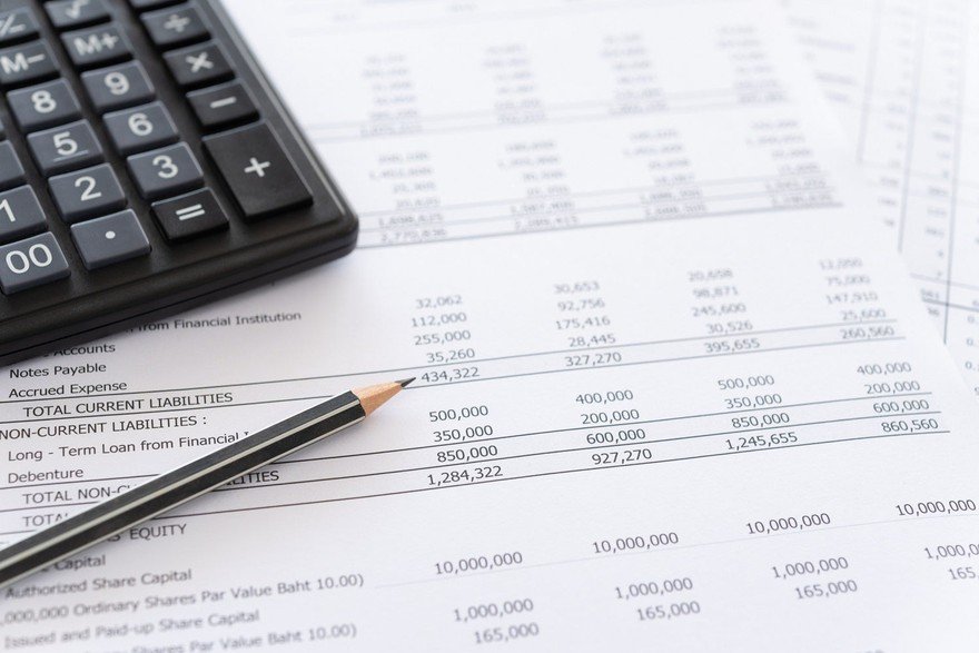 Printed financial statement with a pencil and calculator.