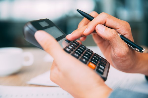 Hands typing into a calculator