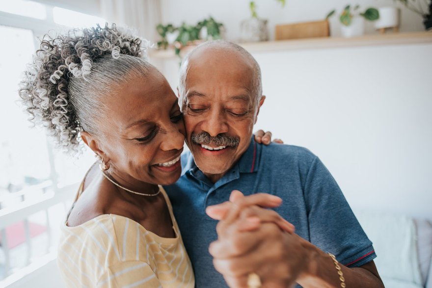 Two people happily dancing at home.