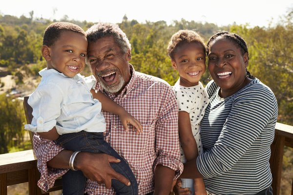 A family with two young kids smiling for the camera