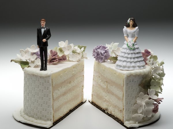 Wedding cake split into two pieces, with the bride on one side and the groom on the other.