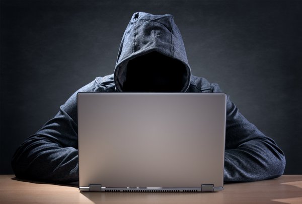 Man on laptop in hooded sweatshirt