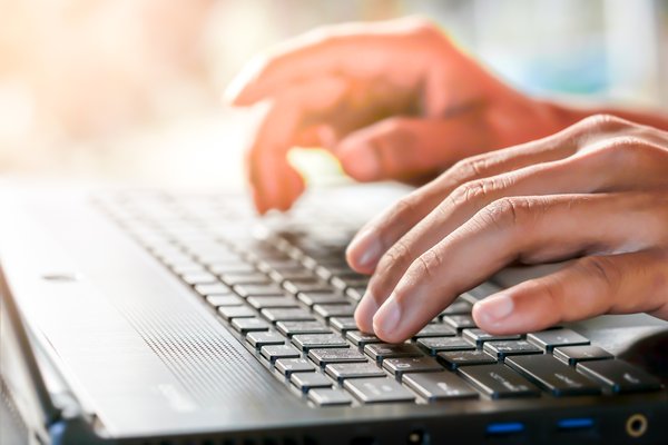 Hands typing on a keyboard.