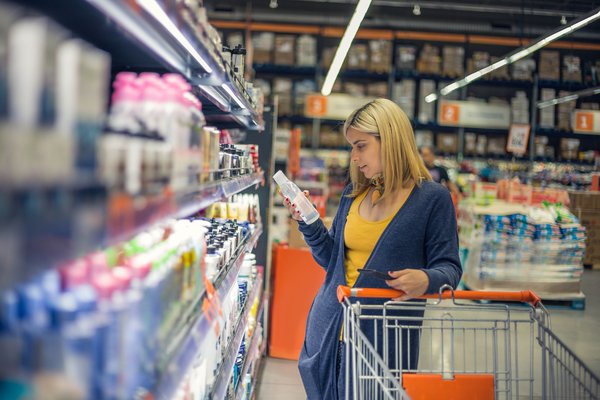 Person shopping in warehouse store with cart.