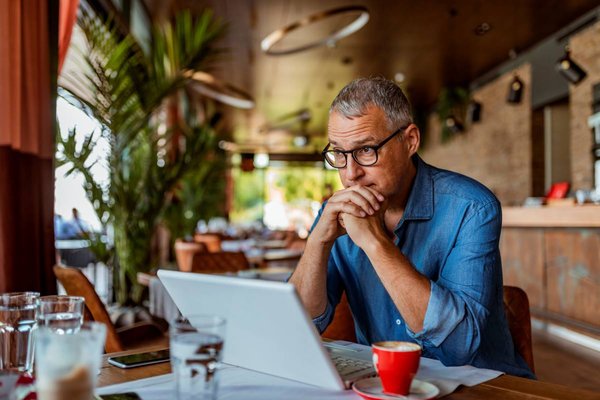 Person with serious expression at laptop.