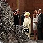 Queen Elizabeth II meets cast members of the HBO TV series 'Game of Thrones' Lena Headey and Conleth Hill while Prince Philip, Duke of Edinburgh shakes hands with Rose Leslie as they views some of the props including the Iron Throne on set in Belfast's Titanic Quarter on June 24, 2014 in Belfast, Northern Ireland. The Royal party are visiting Northern Ireland for three days.