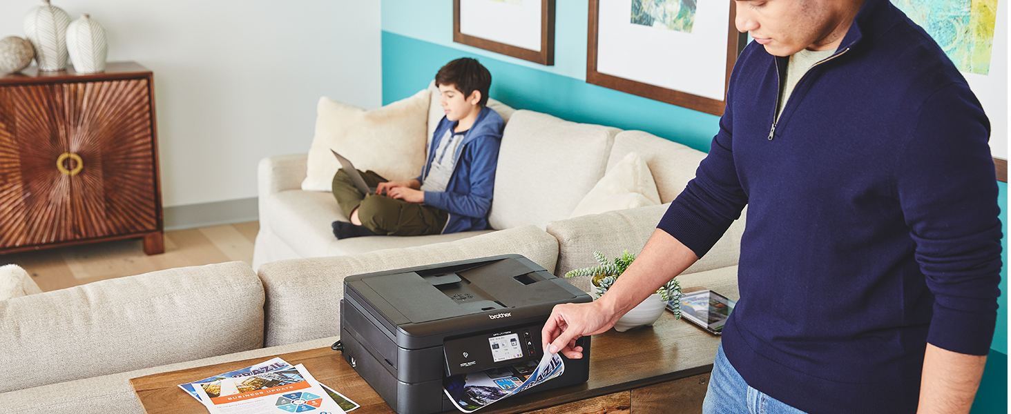 Man removing two-sided full color printout from printer output tray