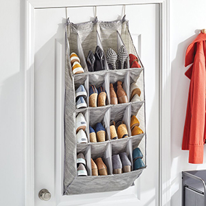 gray shoe organizer filled with shoes hanging on back of white door