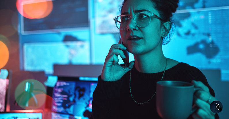 Mariner-Cybersecurity-Woman-with-coffee-on-a-phone-call-during-a-cyber-security-emergency-in-her-office.png