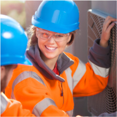 Female apprentice and co-worker working on air-conditioning