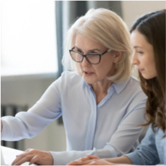 Older professional office worker mentors younger worker