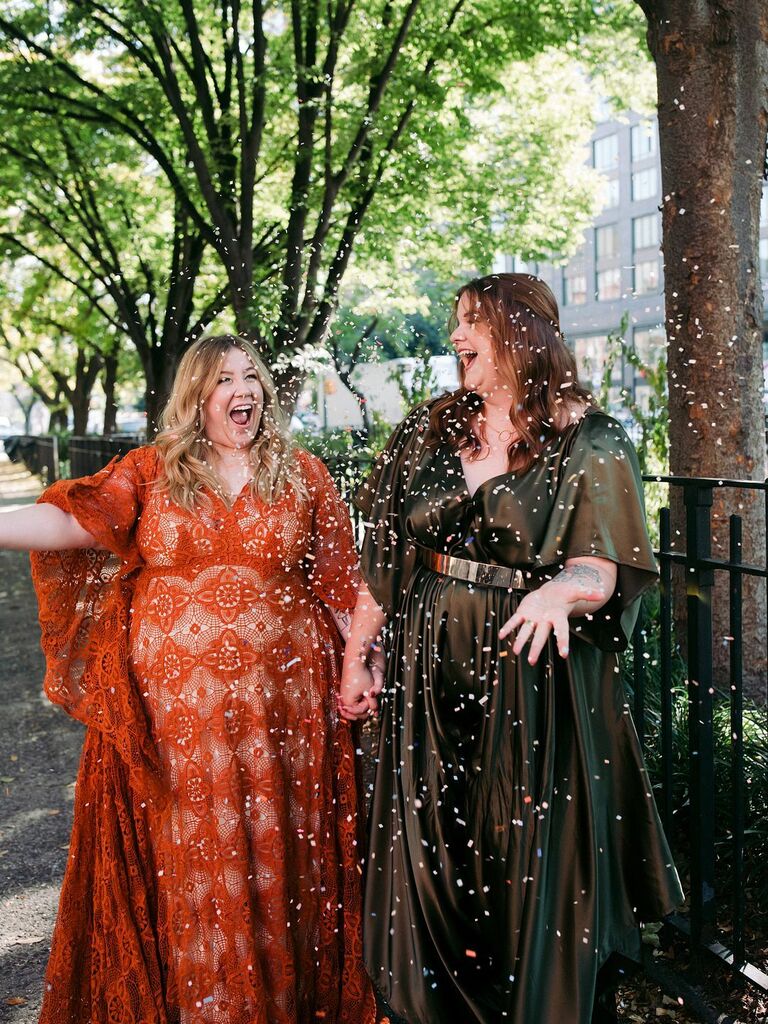 Cute Couple Poses: Couple throws confetti in the air while holding hands and smiling. 