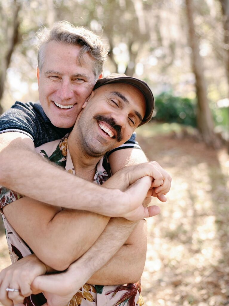 Cute Couple Poses: Couple smile while embracing in a hug. 