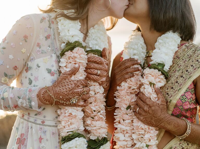 Cute Couple Poses: Couple kiss while wearing beautiful leis. 