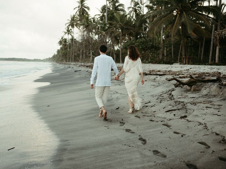 Couple Poses: Couple walks down a beach hand in hand. 