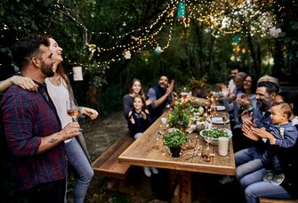 Couple and friends enjoying engagement party in backyard