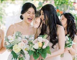 Bride and maid of honor laughing with each other