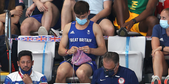 Tom Daley knits in the stands.