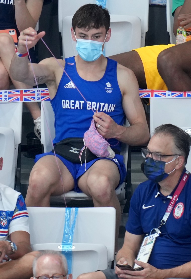 Tom Daley knits in the stands.