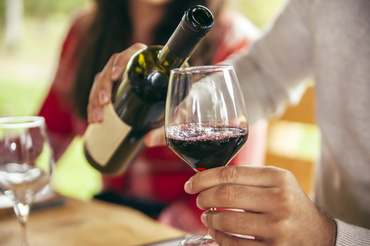 Man pouring red wine into glass