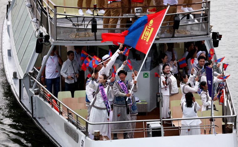 Od Bat-Ochir and Yesugen Oyuntsetseg, Flagbearers of Team Mongolia, are seen waving their flag on a boat.