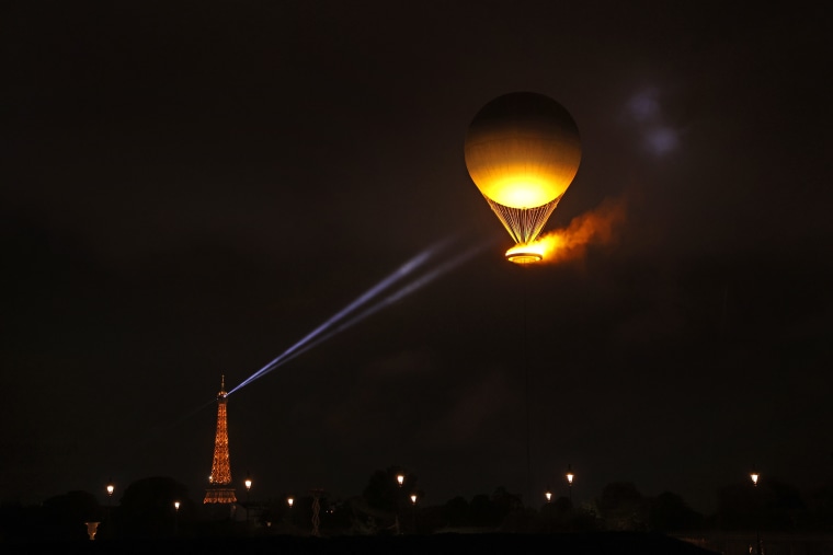 A view of Eiffel Tower's spotlight shining towards the Olympic Cauldron in the sky after being lit by torch bearers Marie-Jose Perec and Teddy Riner during the opening ceremony of the Olympic Games Paris 2024 on July 26, 2024.