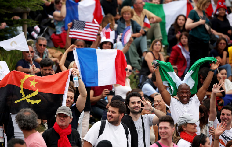 Spectators are seen holding flags  ahead of the Olympic Games ceremony.