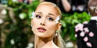 Ariana Grande poses for a portrait during the Met Gala, with white petals on the sides of her eyelids
