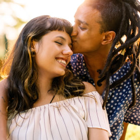 Beautiful young interracial couple being romantic while sitting in a park.