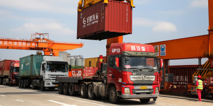 A container is lifted above a truck at a port