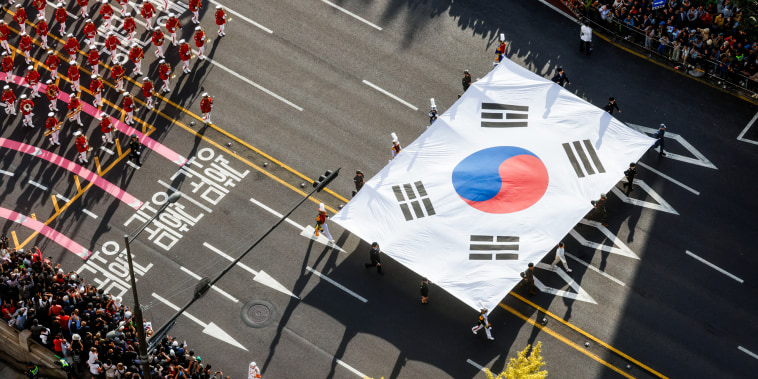 An aerial view of a South Korean flag being carried through a street parade