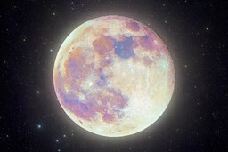 a pink supermoon full moon in front of the night sky