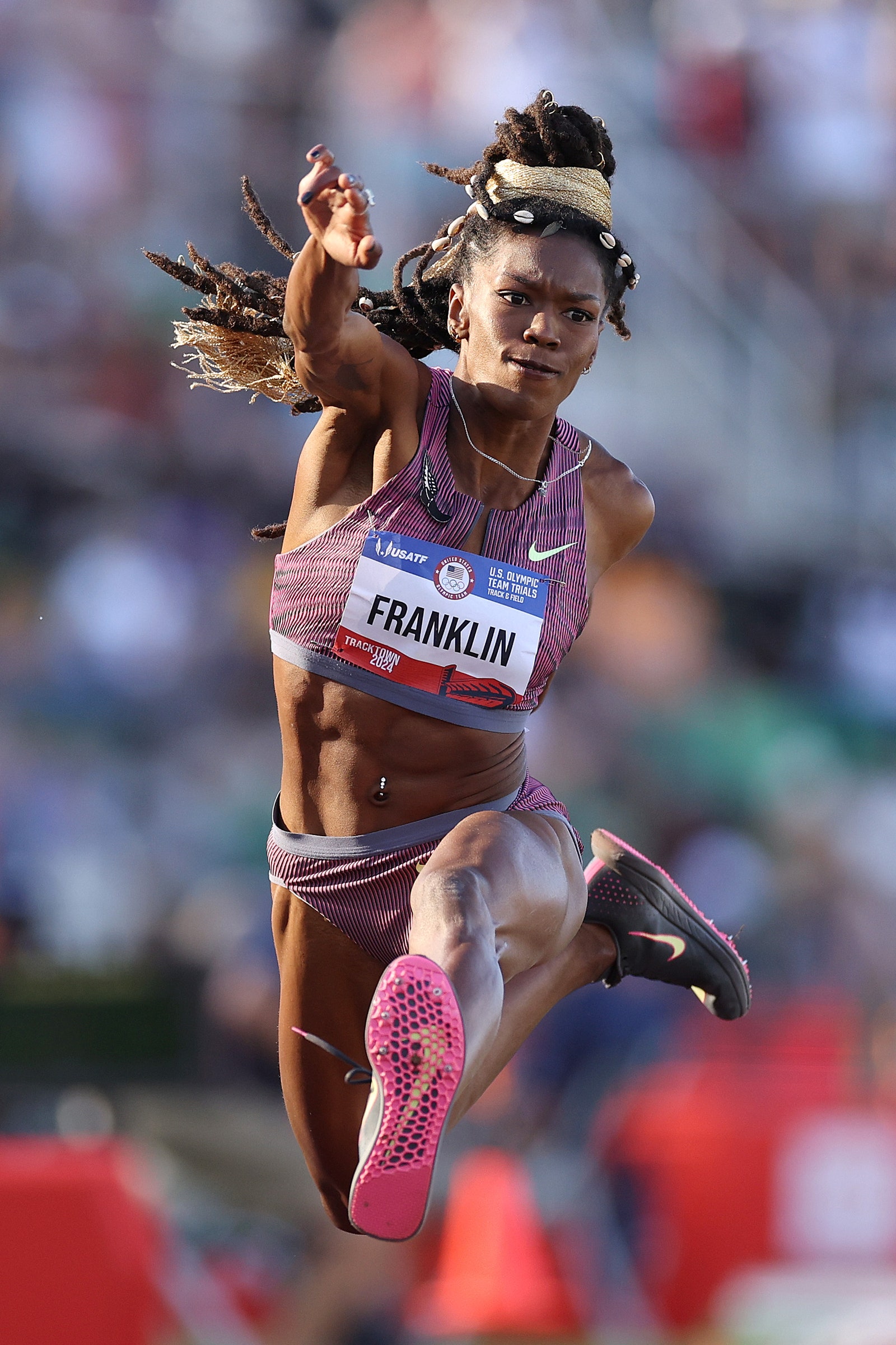 Tori Franklin jumps in the air. She wears her locs halfup.