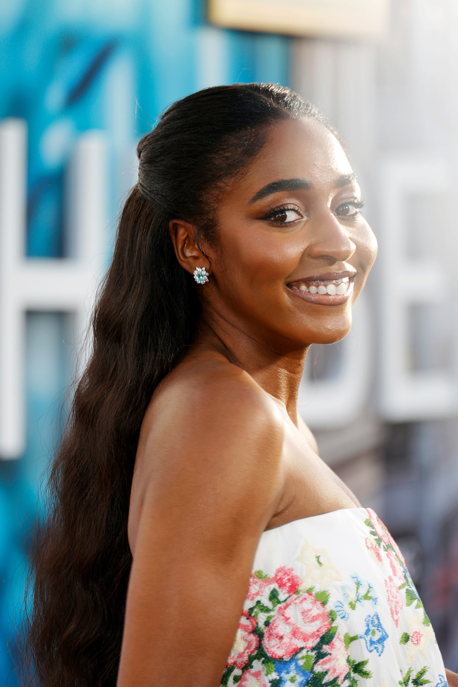 Ayo Edebiri attends The Bear premiere in a strapless floral dress and halfup waves.