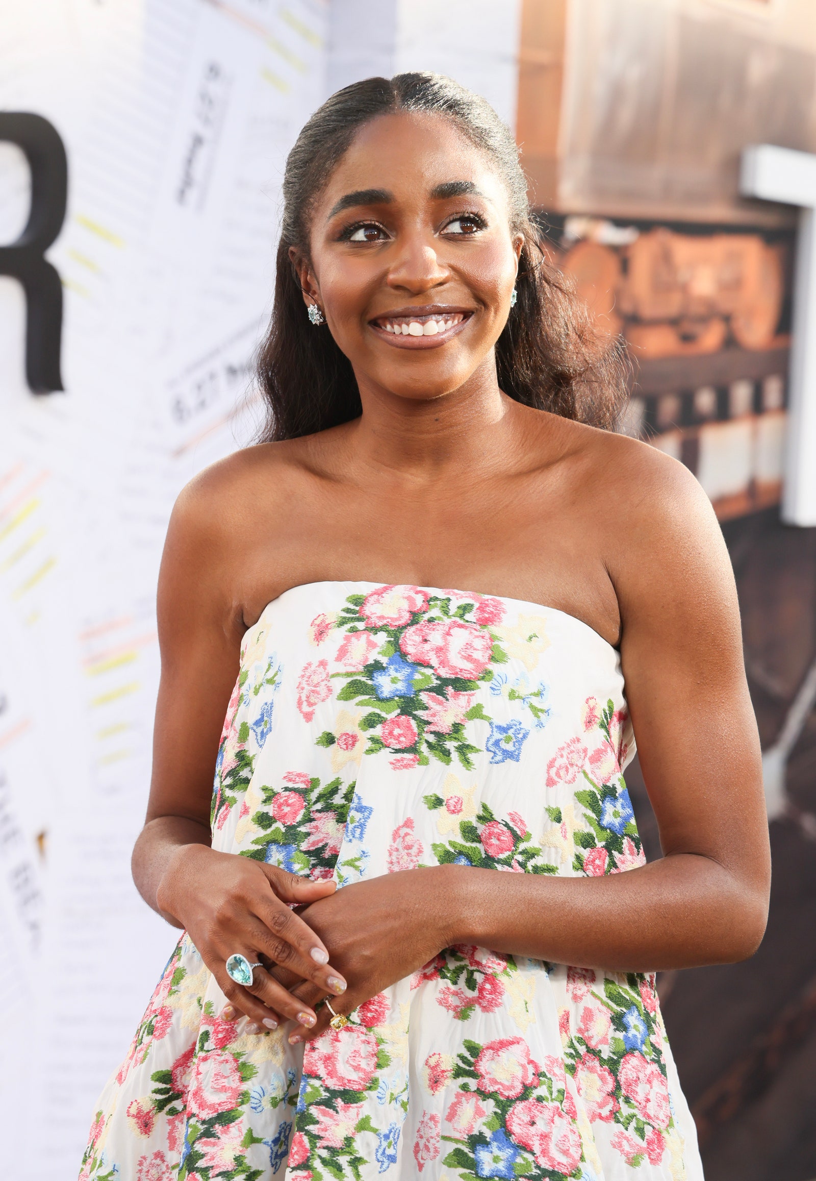 Ayo Edebiri poses at The Bear premiere in a floral dress and long waves.