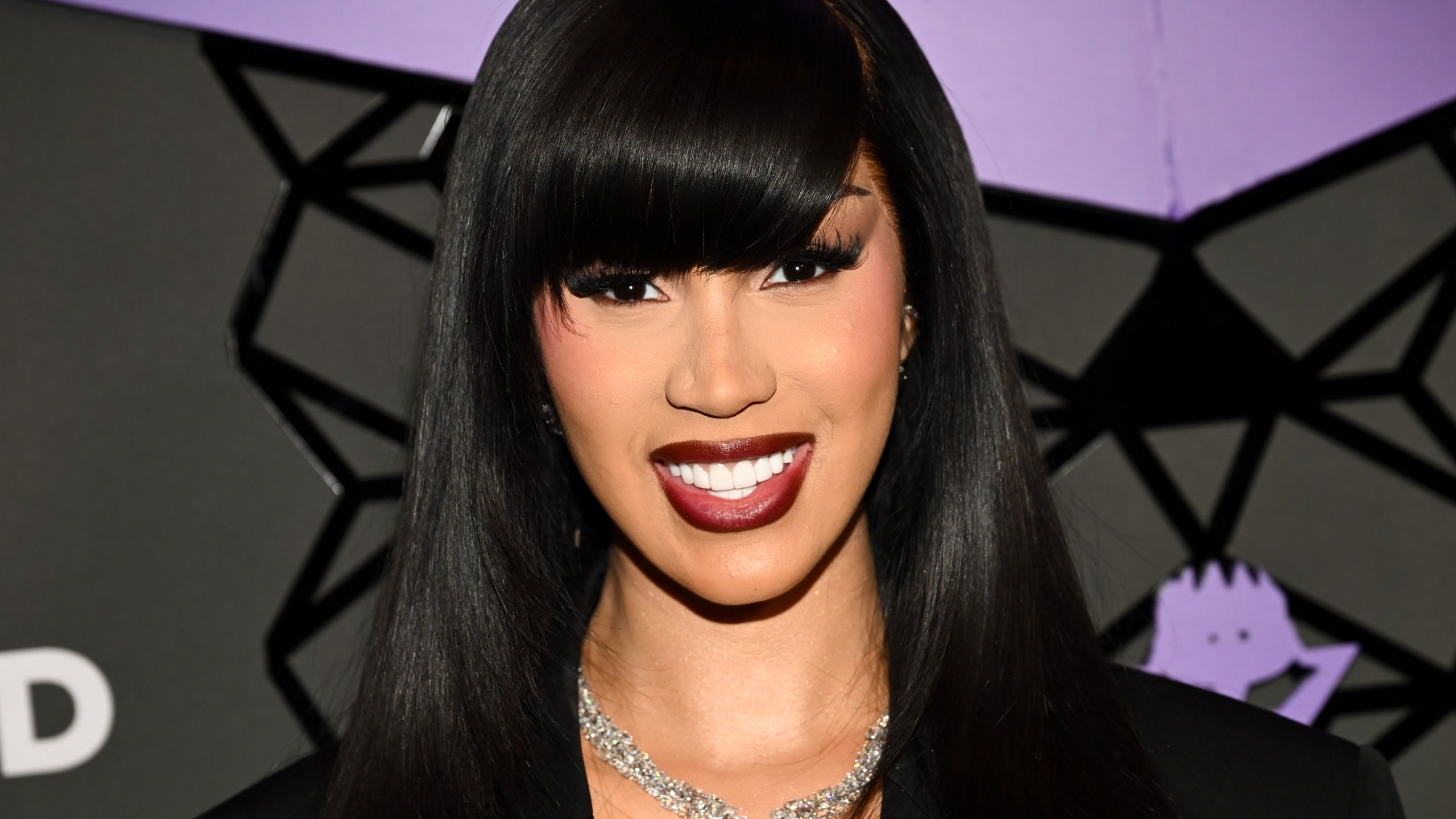 Cardi B attends an event with full angled bangs and a diamond necklace.