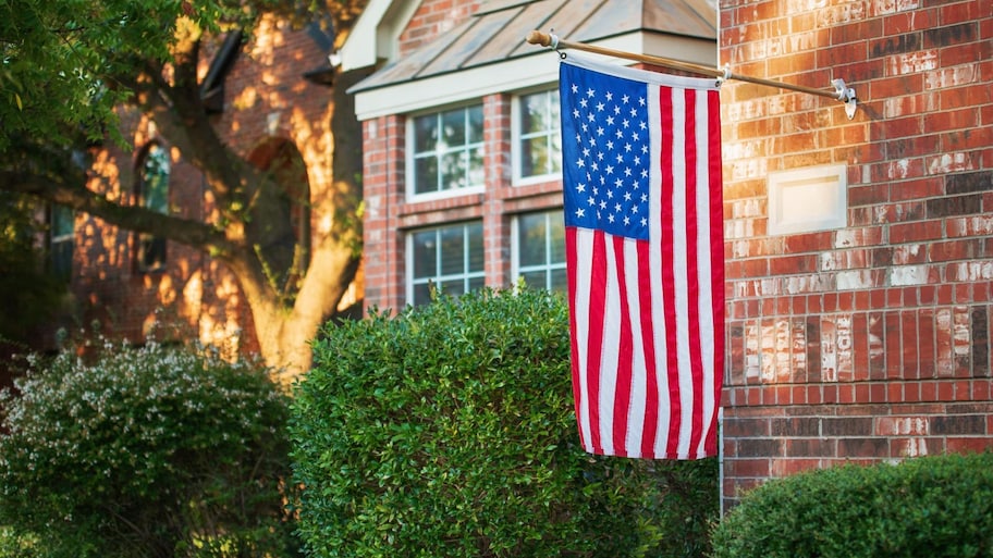 American flag flying at half-staff of a residential home