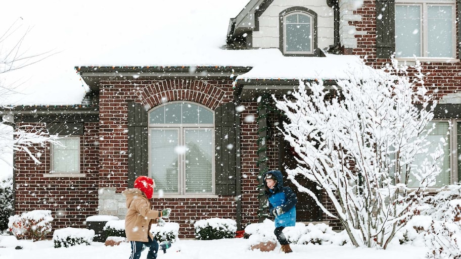 Brothers playing with snow in the yard