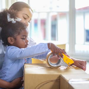 Mom and daughter packing boxes for a move