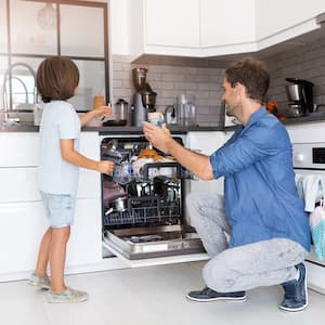 Father and son loading the dishwasher together