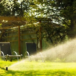 Lawn sprinkler spraying water over grass