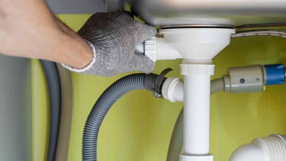 Man repairing a pipe in the kitchen