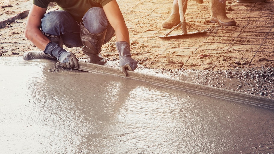 Man spreading concrete for a floor